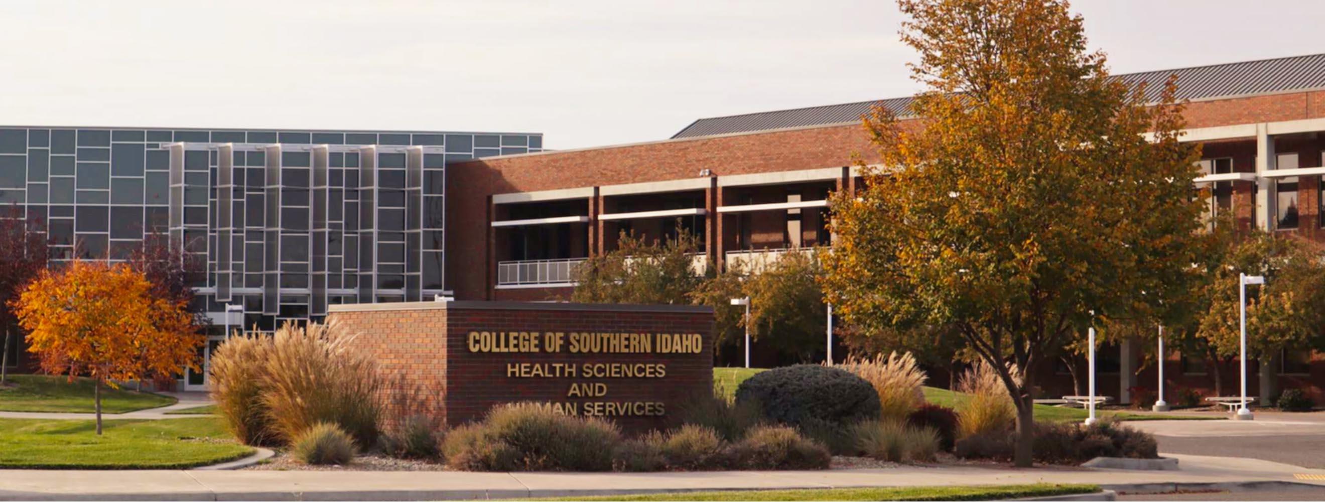 Health Sciences Human Services Building with brick entry sign and gold lettering. 
