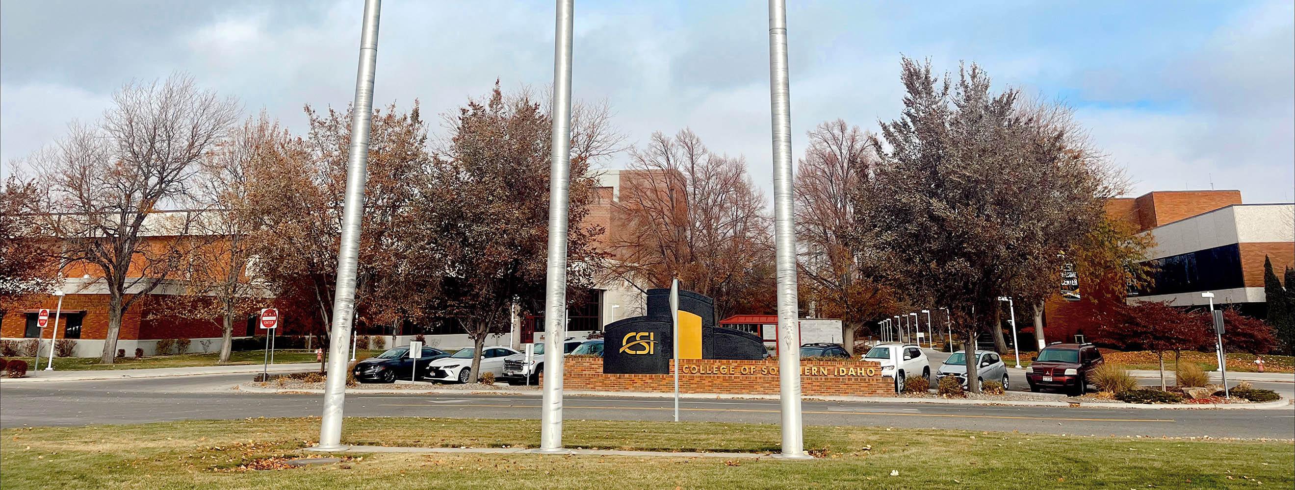 Main Campus Falls Avenue entrance with three large flag poles and sign of CSI