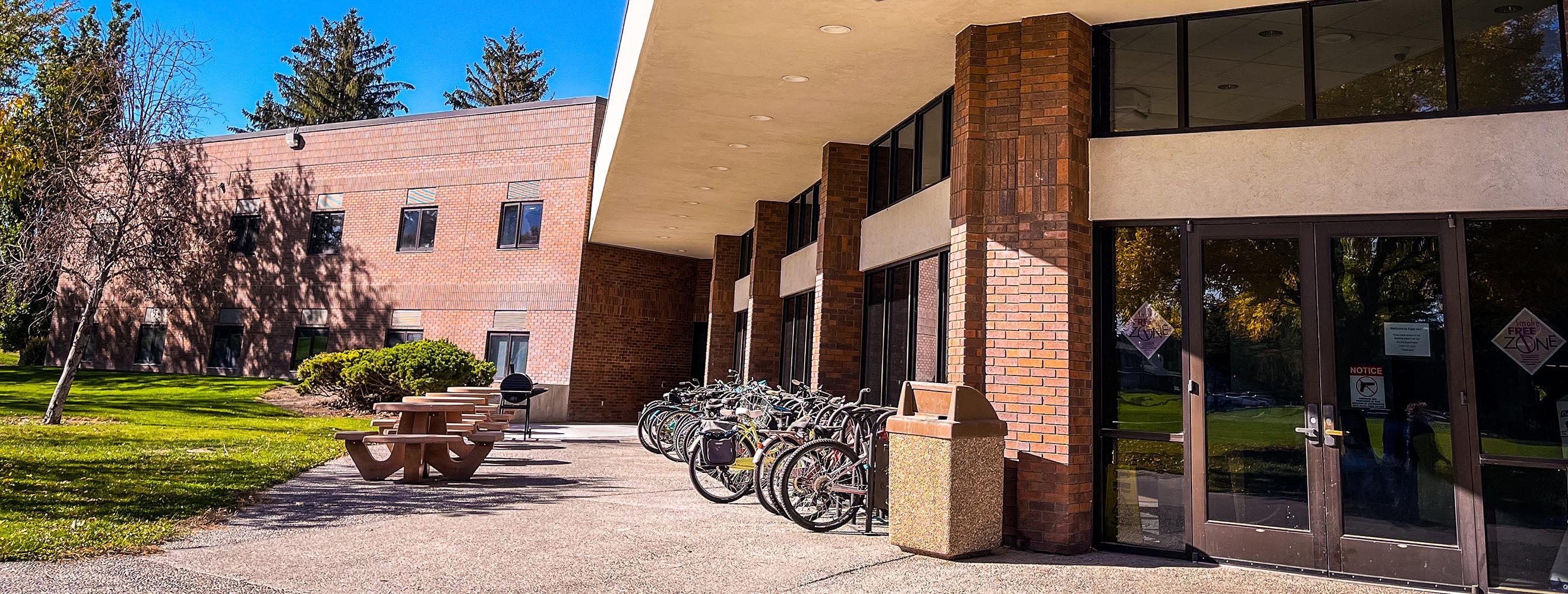 Student housing entrance with bike racks and large tables