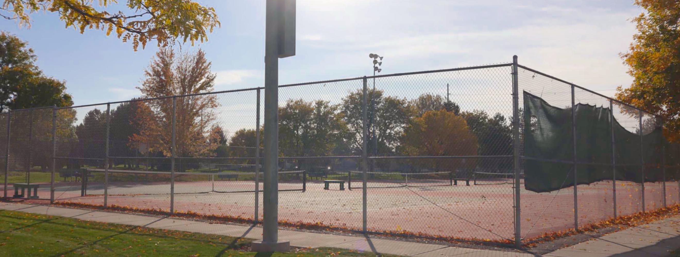 Tennis Courts with multiple playing courts surrounded chain link fences